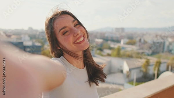 Fototapeta Close-up of young woman taking selfie hand peace sign while standing on balcony