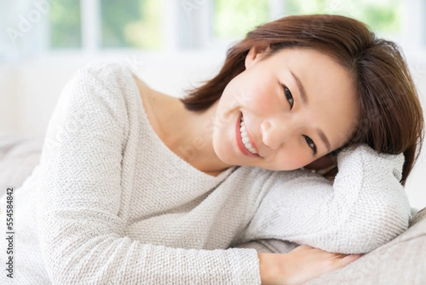 Fototapeta 部屋でリラックスする若い女性