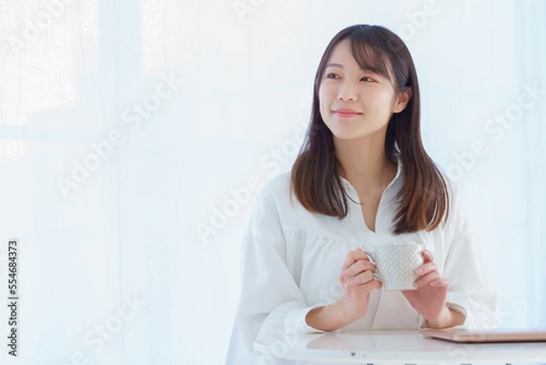 Obraz マグを手に持って微笑む若い女性