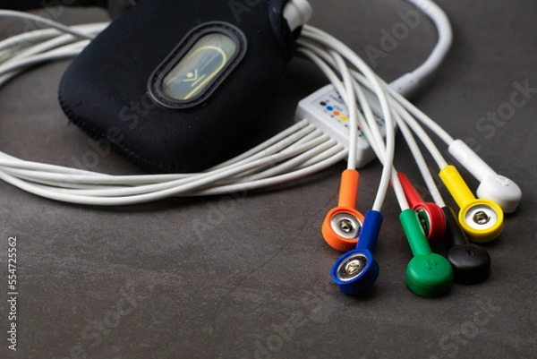 Fototapeta Holter, a medical device for a heart rate measurement with all the colorful cables on industrial gray background
