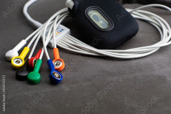 Fototapeta Holter, a medical device for a heart rate measurement with all the colorful cables on industrial gray background