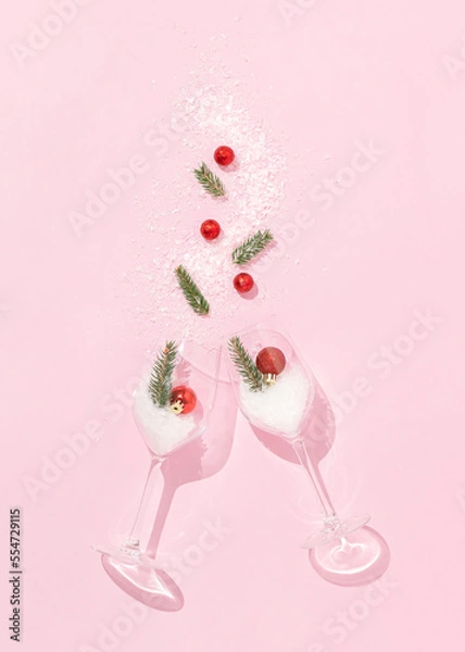 Fototapeta Christmas layout made of two wine glasses with red Christmas balls, fir branches and snow on bright pink background. Minimal New Year celebration concept. Creative winter party aesthetic.