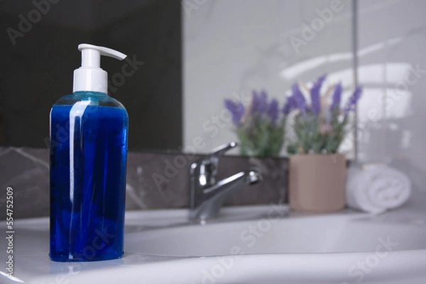 Obraz Bottle of shower gel on sink in bathroom. Space for text