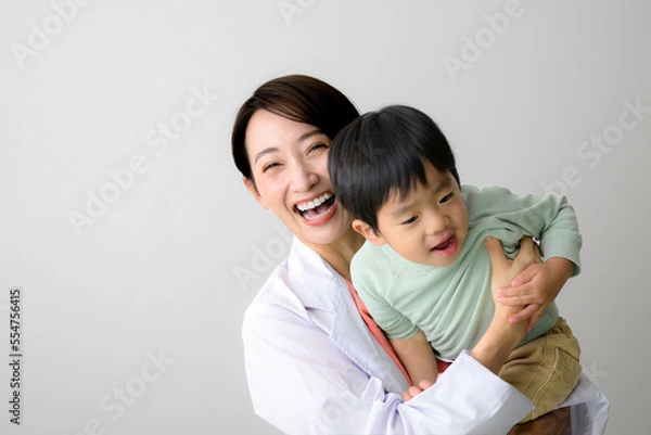 Fototapeta 育児をしながら働く女医さんのイメージ カメラ目線