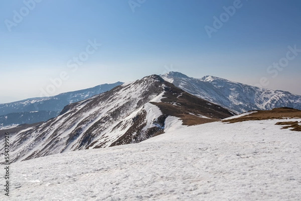 Fototapeta Snow covered alpine pasture with panoramic view on snow capped mountain ridges of summit Zirbitzkogel and Kreiskogel in Seetal Alps, Styria, Austria, Europe. Hiking trail Central Alps in sunny winter