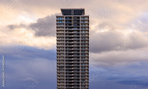 Obraz Dramatic clouds behind apartment tower at sunset