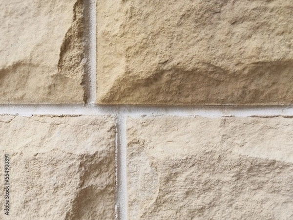 Fototapeta Coarse sand coloured textured local stone block background with space for copy