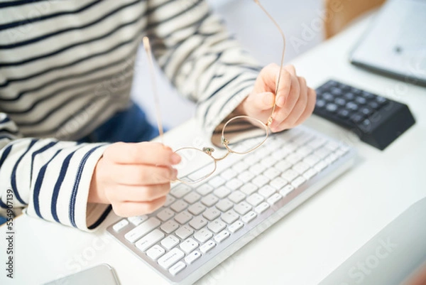 Fototapeta メガネをかけてデスクに向かう若い女性