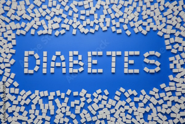 Fototapeta Diabetes word and a frame made from sugar cubes on blue background
