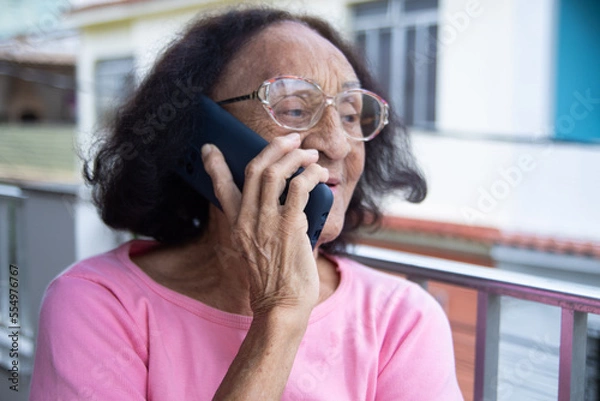 Fototapeta Brazilian Senior woman have a conversation on smartphone