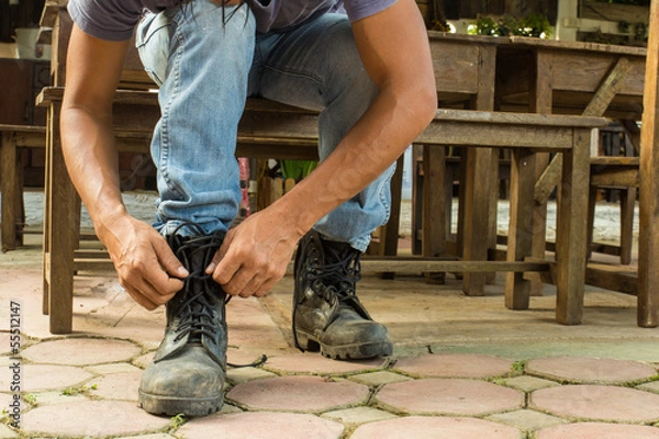 Obraz man getting dressed boots