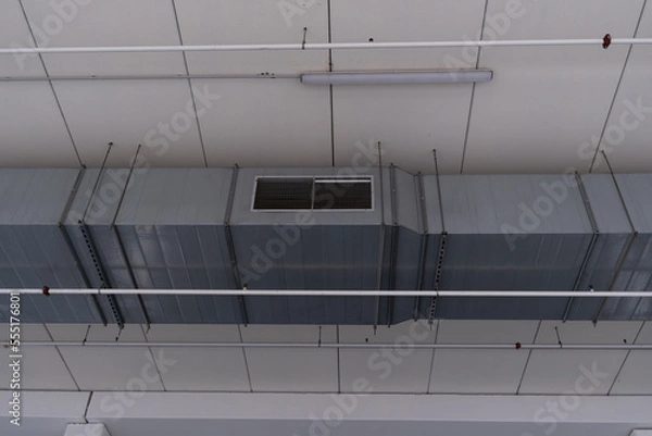 Fototapeta View of ventilation tube hanging on the ceiling and light of a commercial center. Ventilation system, hot and cold air.