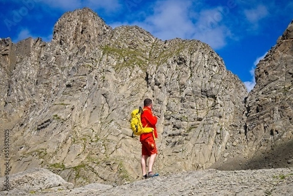 Fototapeta A man hikes the trail to Balcon de Pineta, a popular route in the Spanish Pyrenees
