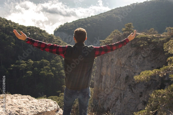 Obraz A traveler with a backpack points the way. A man admires a beautiful view of nature.