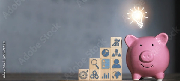 Fototapeta Saving  money.Pig piggy bank with light bulb.The icon finance on wood block. save money.investment,bank,finance,Photo financial saving and Saving.