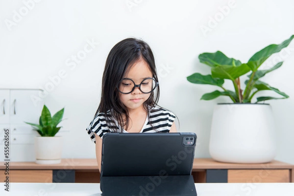 Obraz Asian child girl student wow excited on video call learning to studying online class or person learn from home school with tablet