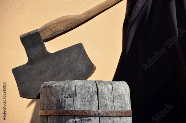 Fototapeta Headsman's axe hewed in old wooden chunk