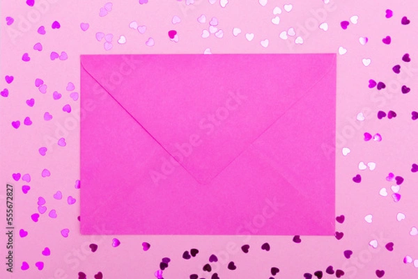 Fototapeta Pink mail envelope and heart-shaped sequins on a pink background. The concept of Valentine's day, love, dating and wedding. copy space, background for design