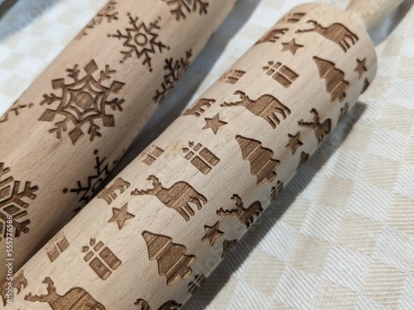 Fototapeta wooden rolling pins with Christmas and New Year patterns for making cookies for the holiday
