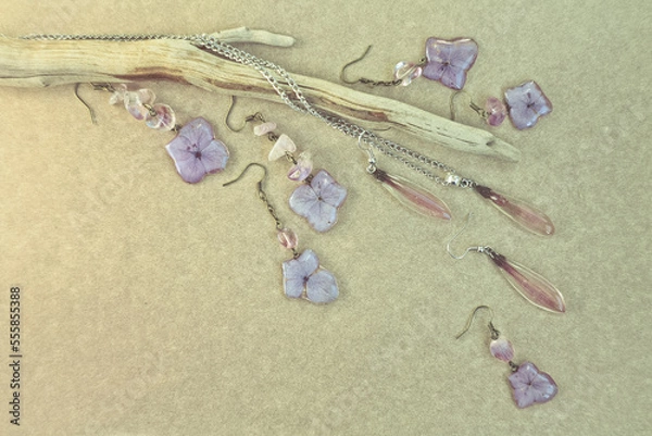 Obraz Close up earrings and pendant with floral elements photo. Top view photography with stick and plywood on background. High quality picture for wallpaper, travel blog, magazine, article