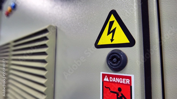Obraz Concepts for work and workplace safety. Electric shock warning indicators mounted to the electric control cabinet warn of danger. Caution: use extreme caution when servicing electrical equipment
