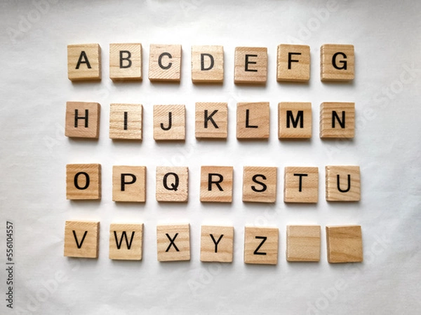 Fototapeta Letters of the alphabet on wooden parts on white background