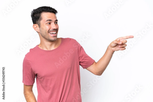Fototapeta Young handsome man over isolated white background pointing finger to the side and presenting a product