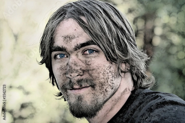 Fototapeta Handsome young man has his face covered with mud 