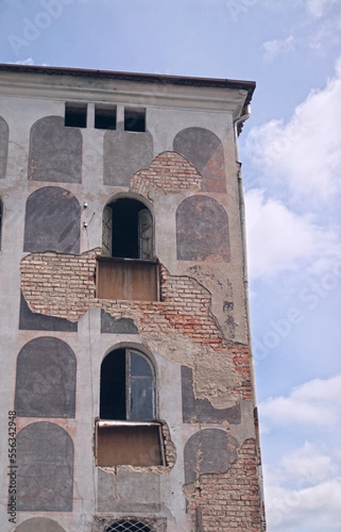Fototapeta Facade of an old historic brick building with beautiful paintings. Uninhabited building, probably intended for renovation