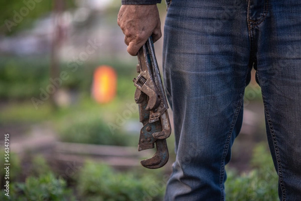 Fototapeta man plumber holding old pipe wrenches