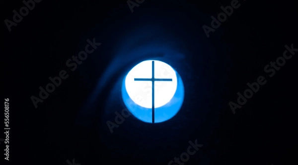 Fototapeta Art photo - a cross on the background of a light, glowing circle. Christian symbols in art photography.