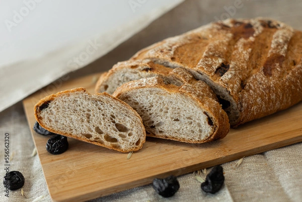Obraz white bread lying on the board, photo in the style of rustic,sliced bread on a beige background, a place for text