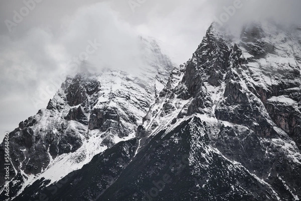 Fototapeta Dreamy mysterious winter landscape with fog and snow covered mountains and clouds in the sky