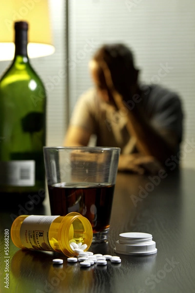 Fototapeta Depressed man with wine and prescription medication, vertical