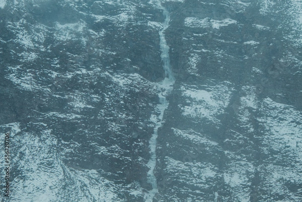 Fototapeta Frozen waterfall on the Himalayan mountains during the winter season at Lahaul in Himachal Pradesh, India. Snow covered mountains during the winter. Natural winter background of the Himalayas. 