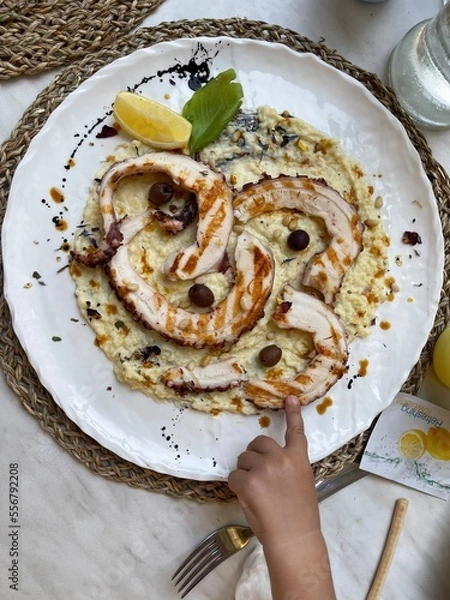 Fototapeta A plate with seafood with a baby hand