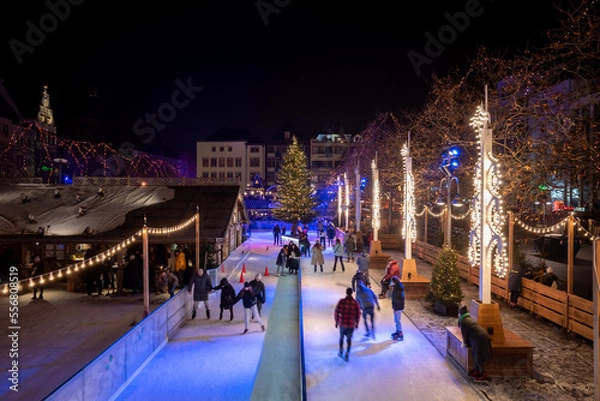 Fototapeta Top night view over temporary ice rink with people enjoy ice skating at Heumarkt, famous Christmas market square in Köln.