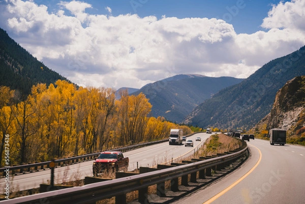 Fototapeta Driving down a highway in the fall through the Rocky Mountains