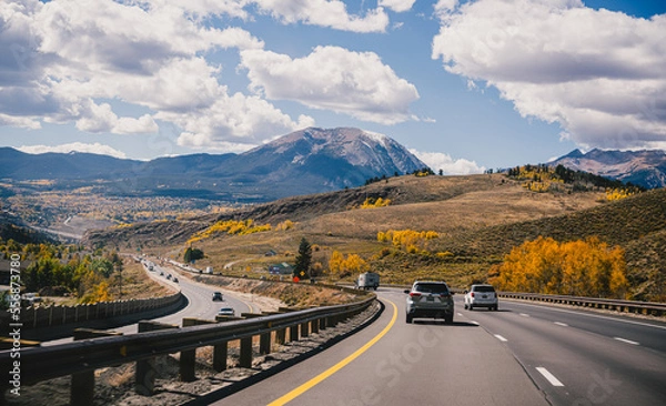 Fototapeta Driving down a highway in the fall through the Rocky Mountains