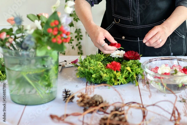 Fototapeta 生花を使った華やかなフラワーアレンジメント　手作りの花のリース　女性フラワーデザイナー