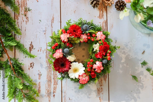 Fototapeta 生花を使った華やかなフラワーアレンジメント　手作りの花のリース　女性フラワーデザイナー