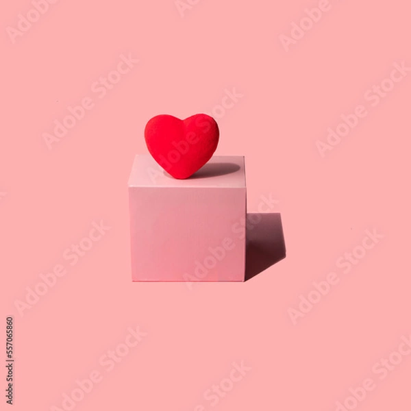 Fototapeta Red heart and light pink cube on pastel background. Modern Valentine's Day concept. Creative love idea. Minimalistic Mother's Day composition.