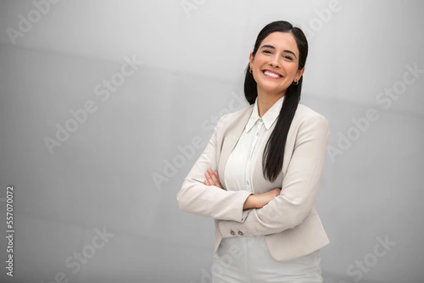 Fototapeta Beautiful hispanic business woman, executive, boss, CEO, entrepreneur in a suit, smiling and standing confidently with arms crossed