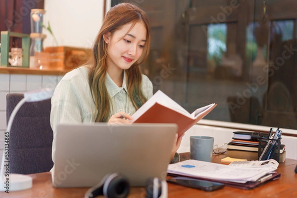 Fototapeta Business concept, Woman entrepreneur reading a book while working in coworking space office