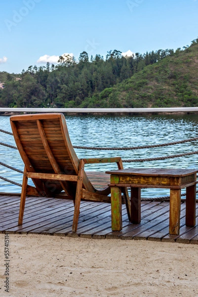 Fototapeta An empty wooden chair and small table facing the view with beautiful lake and mountains. Vertical
