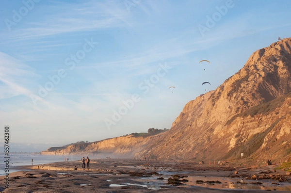 Fototapeta Paragliders over the tops of coastal cliffs