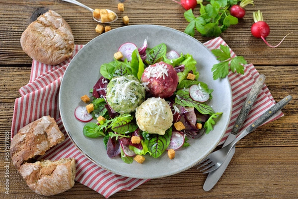 Obraz Südtiroler Vegetarierteller mit Knödeltrio auf bunten Blattsalaten mit Wildkräutern – Vegetarian South Tyrolean dumpling trio on mixed leaf salad