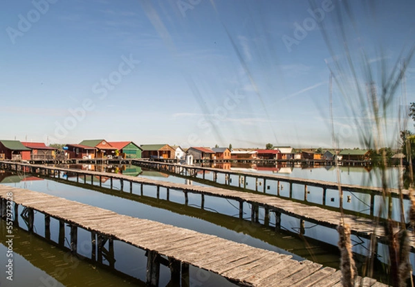 Fototapeta Oriental village on a canal. Houses on stilts. Flooded houses Floating village. Paths on water