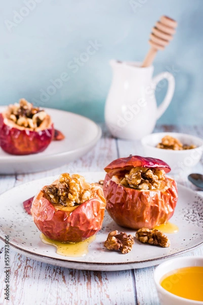 Fototapeta Whole baked apples with honey and walnuts on a plate. Homemade dessert. Vertical view