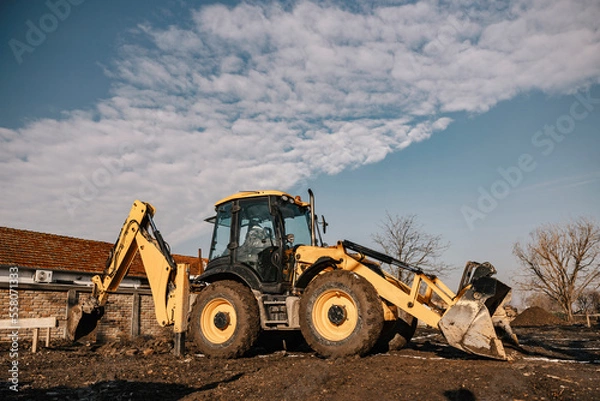 Obraz An excavator digging soil on construction site.